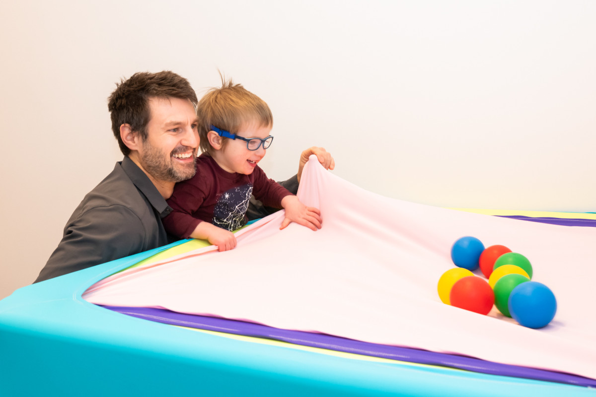 Boy playing with balls in sensory room.